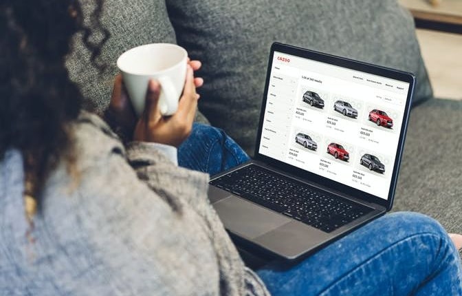 Eine Kundin kauft auf ihrem Laptop online ein Auto mit Cazoo