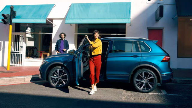 Mujer saliendo de un Volkswagen Tiguan azul